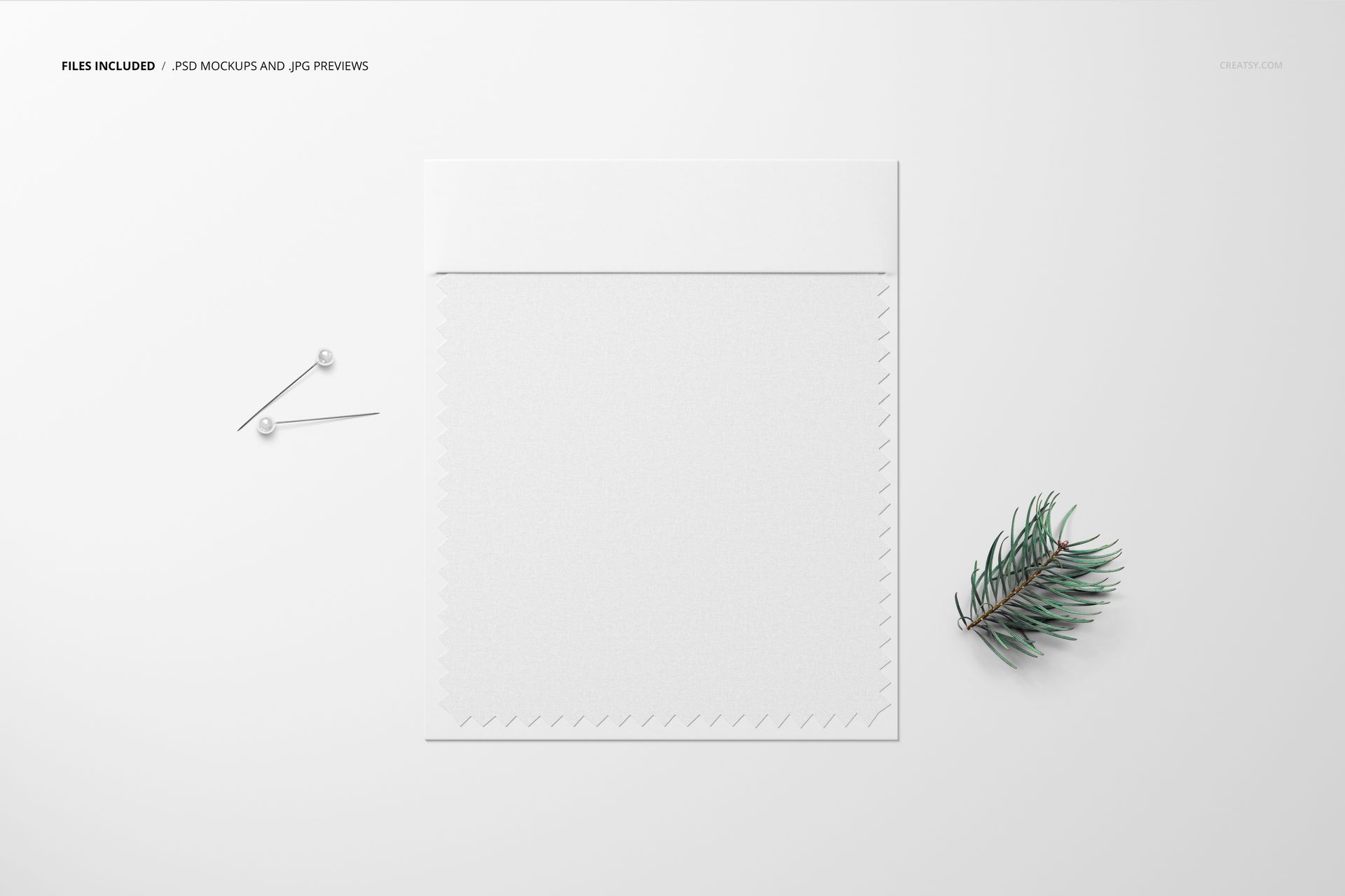 Fabric swatch mockup displayed on a white surface with two pins and a small pine branch beside it, top view.