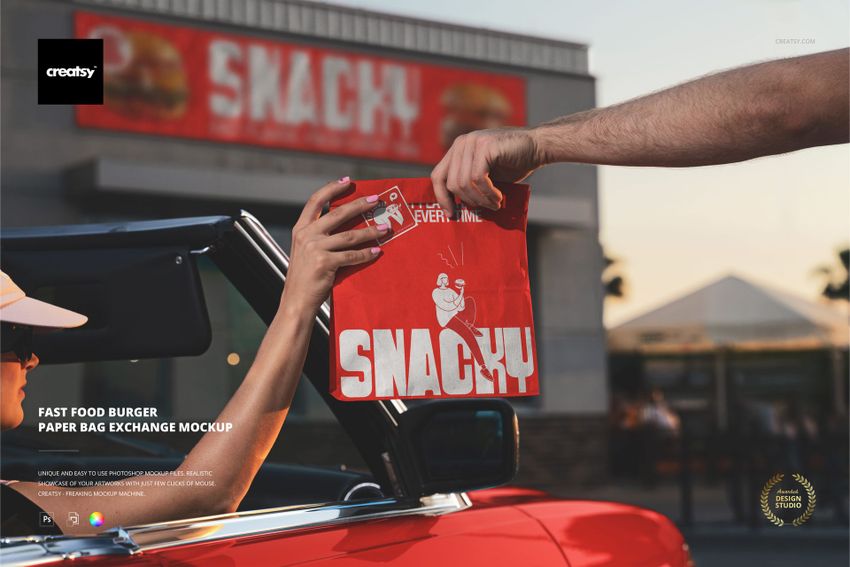 PSD mockup featuring a red burger paper bag with white print exchanged between two hands in front of a fast food building.