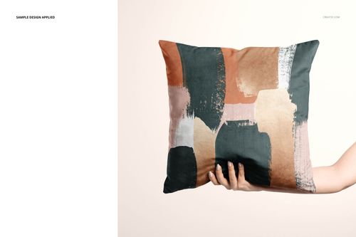 Front view of a velvet cushion cover mockup featuring a hand holding a pillow with multicolor abstract design.