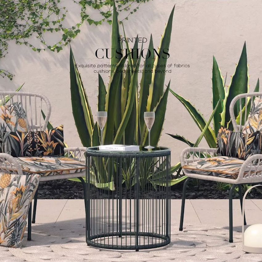 Outdoor furniture set mockup featuring two chairs with patterned cushions and a round metal table, set against a white wall with tall green plants.