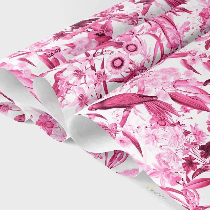 Wrapping tissue paper mockup featuring sheets with a pink botanical and bird pattern on a white background, viewed close up.