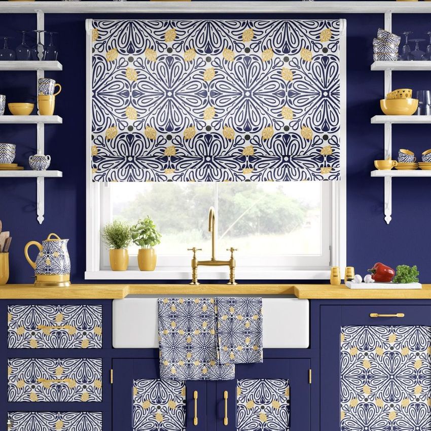 Provence style kitchen design mockup featuring blue and yellow patterned cabinets, window shade, and towels in a bright kitchen.