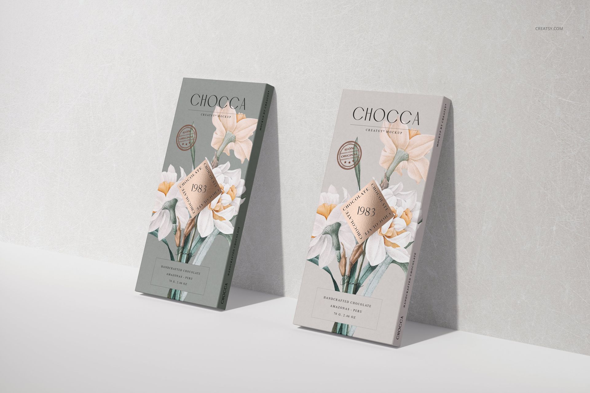 Two chocolate bar packaging mockups displayed upright on a light surface, featuring floral illustrations and muted colors.