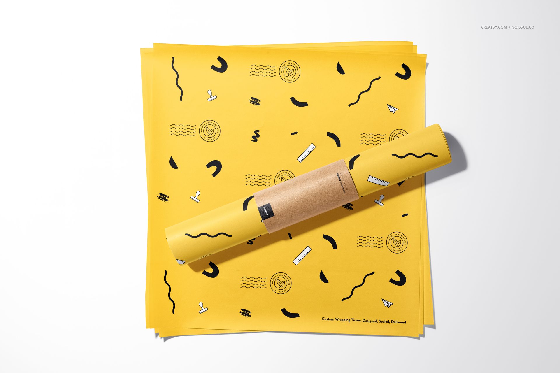 Noissue food safe paper mockup featuring bright yellow sheets with playful abstract designs, displayed from above.