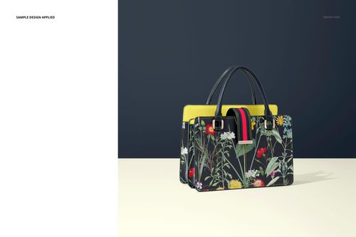 Front view of a leather handbag mockup with floral pattern, black handles, and yellow accents on a neutral surface.