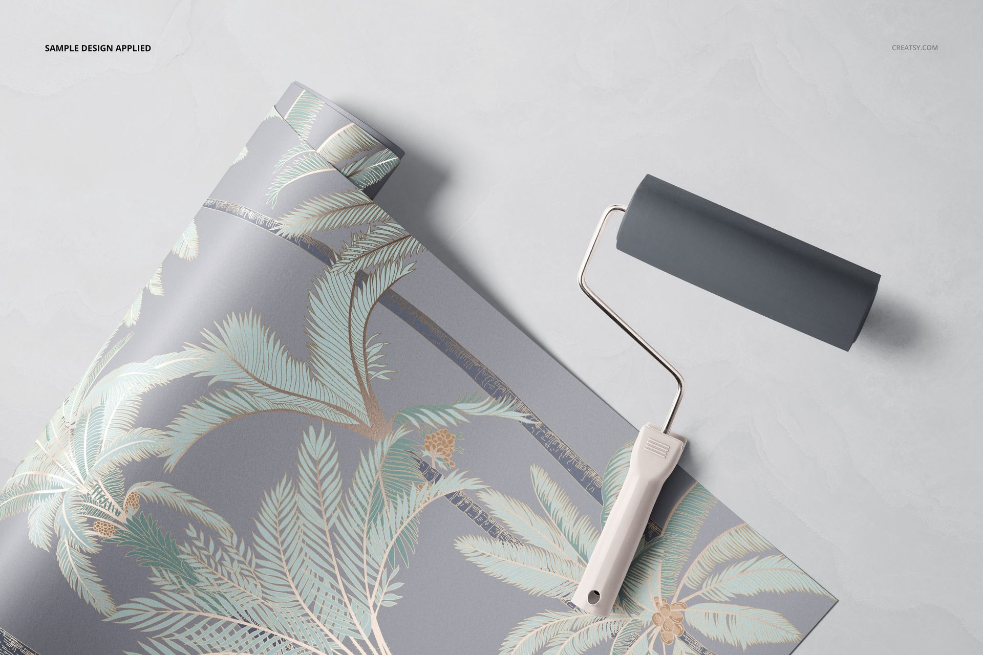 Tropical-themed paper wallpaper mockup featuring palm leaves in pastel tones, partially unrolled with a paint roller nearby.