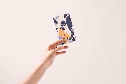 Front view of a person holding a tarot card mockup with colorful abstract artwork, set against a white surface.