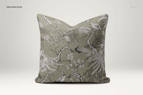Front view of a reversible piped pillow mockup showing intricate crane and blossom motifs on a neutral background.
