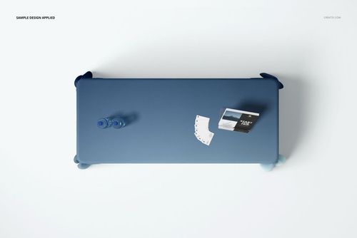 PSD mockup showing a blue polyester tablecloth from above, with water bottles and printed cards on a white background.