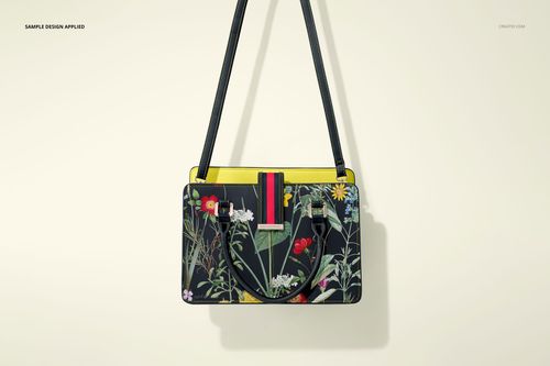 Leather handbag mockup featuring a botanical print, black straps, and yellow trim, displayed on a neutral background.