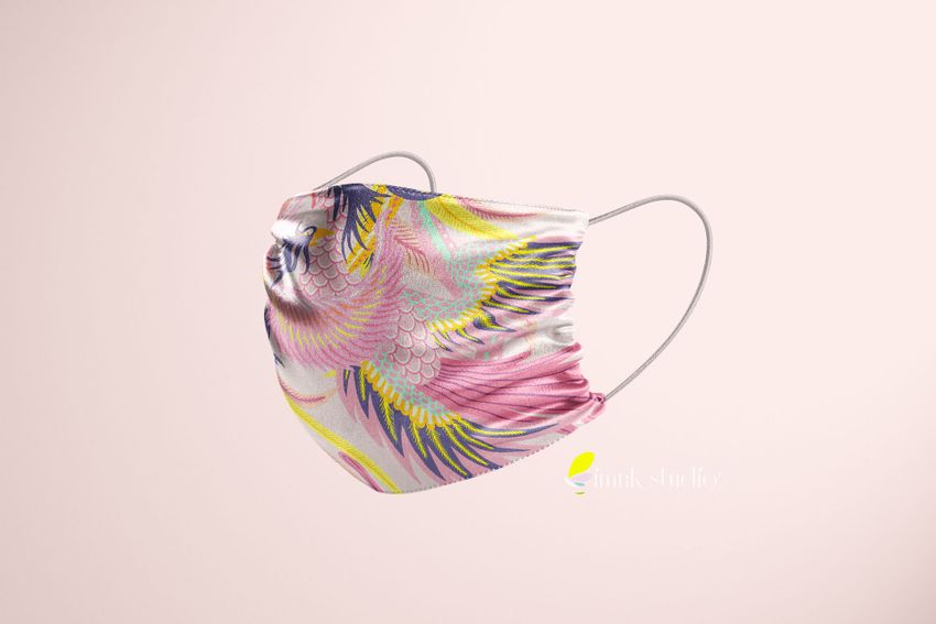 Silk face mask mockup featuring a colorful abstract feather pattern in pink, yellow, and blue on a light background.