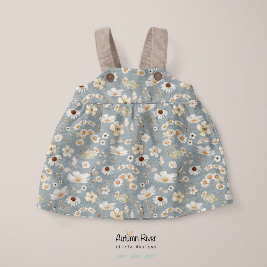 Baby dress mockup featuring a blue floral pattern with white and yellow flowers, shown flat on a light beige background.
