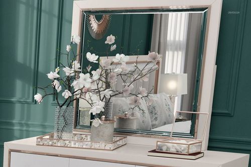 Elegant bedroom mockup with flanged pillows visible in mirror, white dresser, glass vase, and green walls.