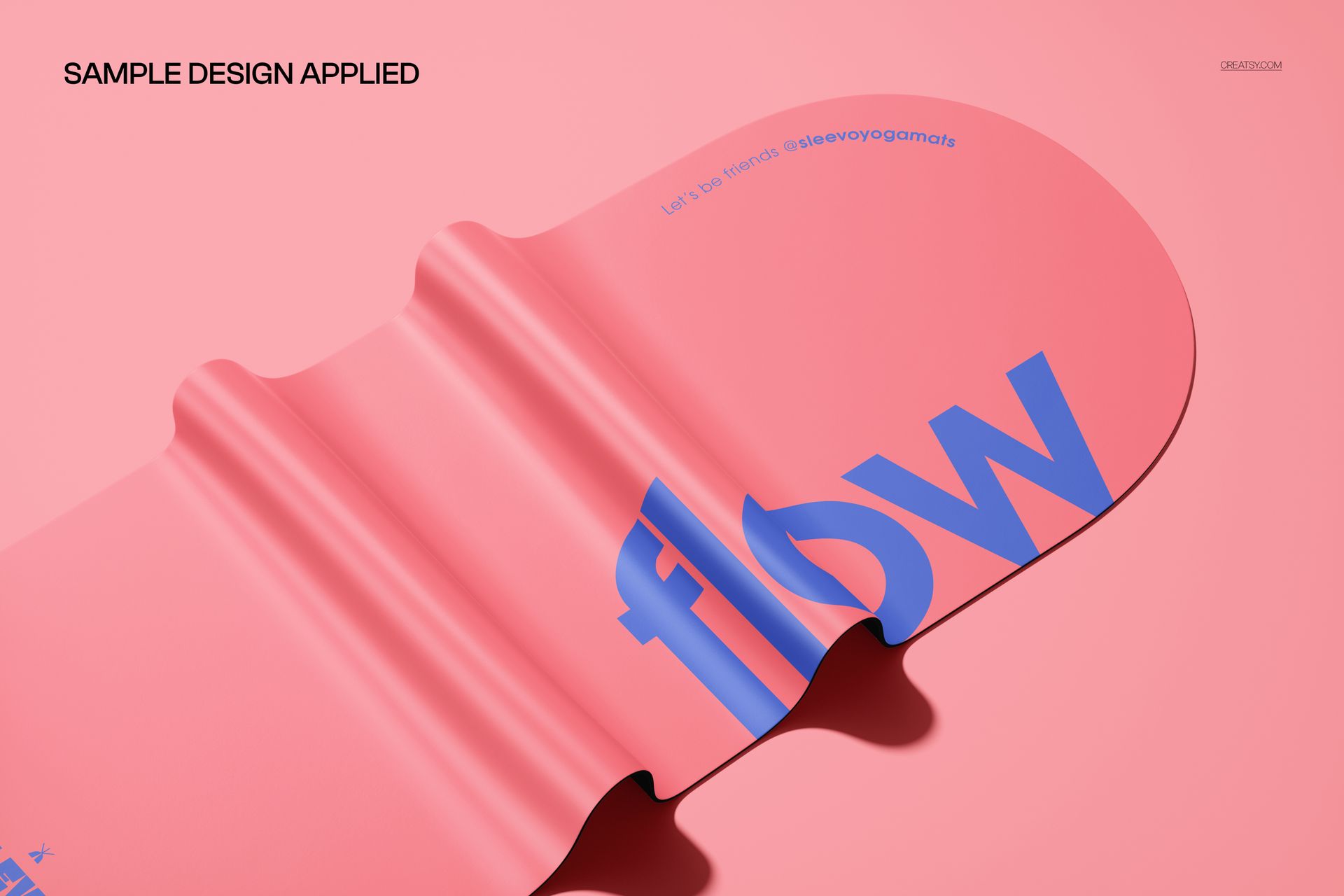 Folded pink PU oval yoga mat mockup with blue lettering, captured from an angled close-up perspective.