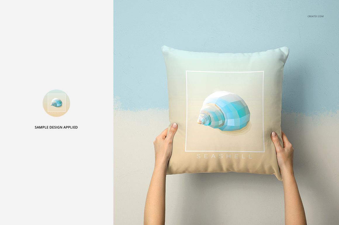 Front view of a mockup pillow featuring a geometric seashell print, shown in a neutral home setting with hands holding it.