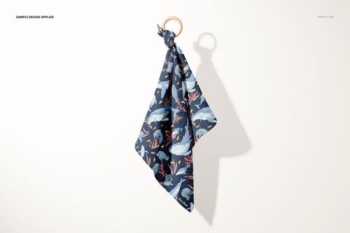 Muslin cloth wooden teether mockup showing a patterned dark blue fabric tied to a round wooden ring, front view on a light background.