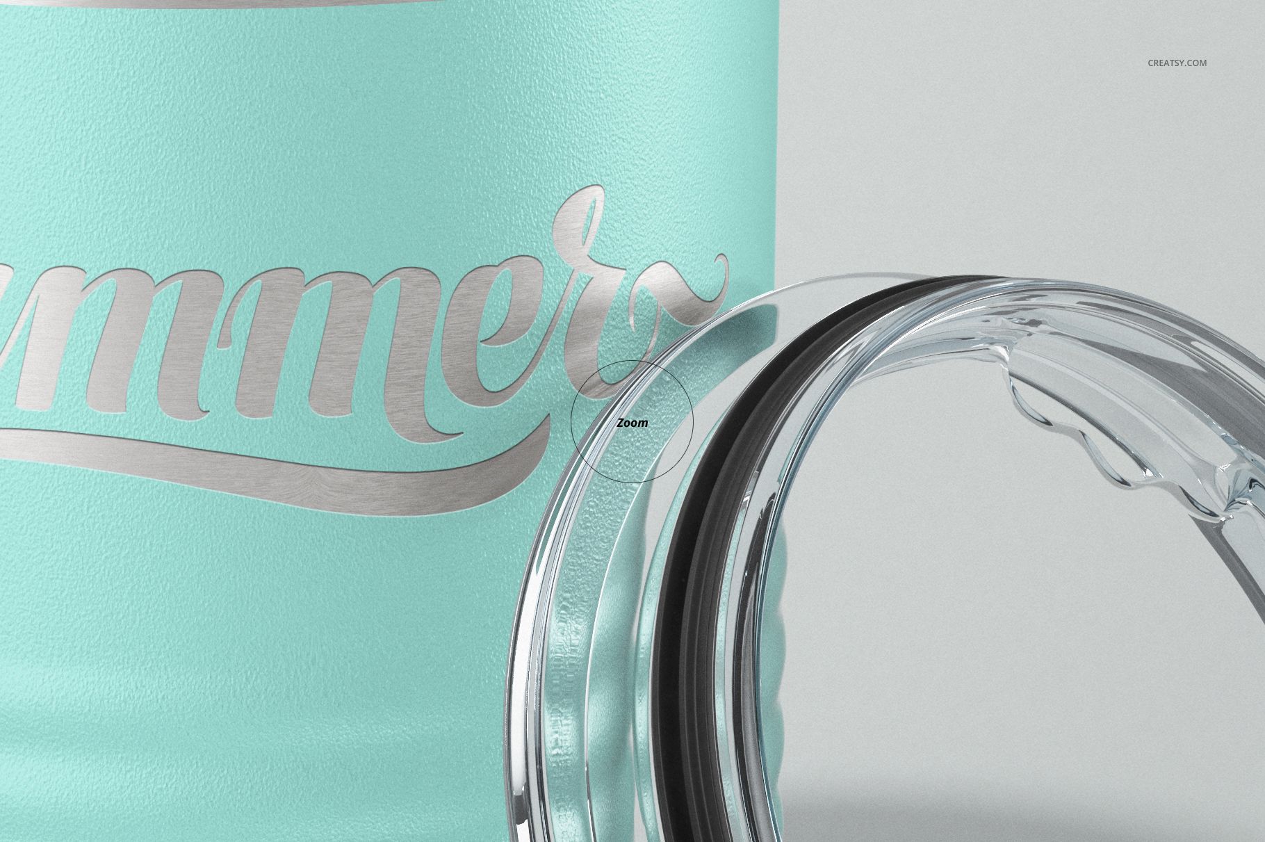 Close-up view of a powder-coated tumbler in light turquoise with engraved metallic script and clear plastic lid detail.