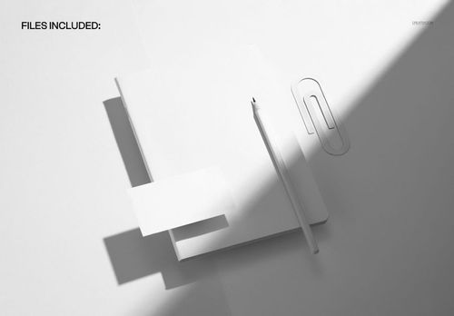 Stationery mockup scene showing a closed notebook, pencil, paperclip, and blank card on a white background.