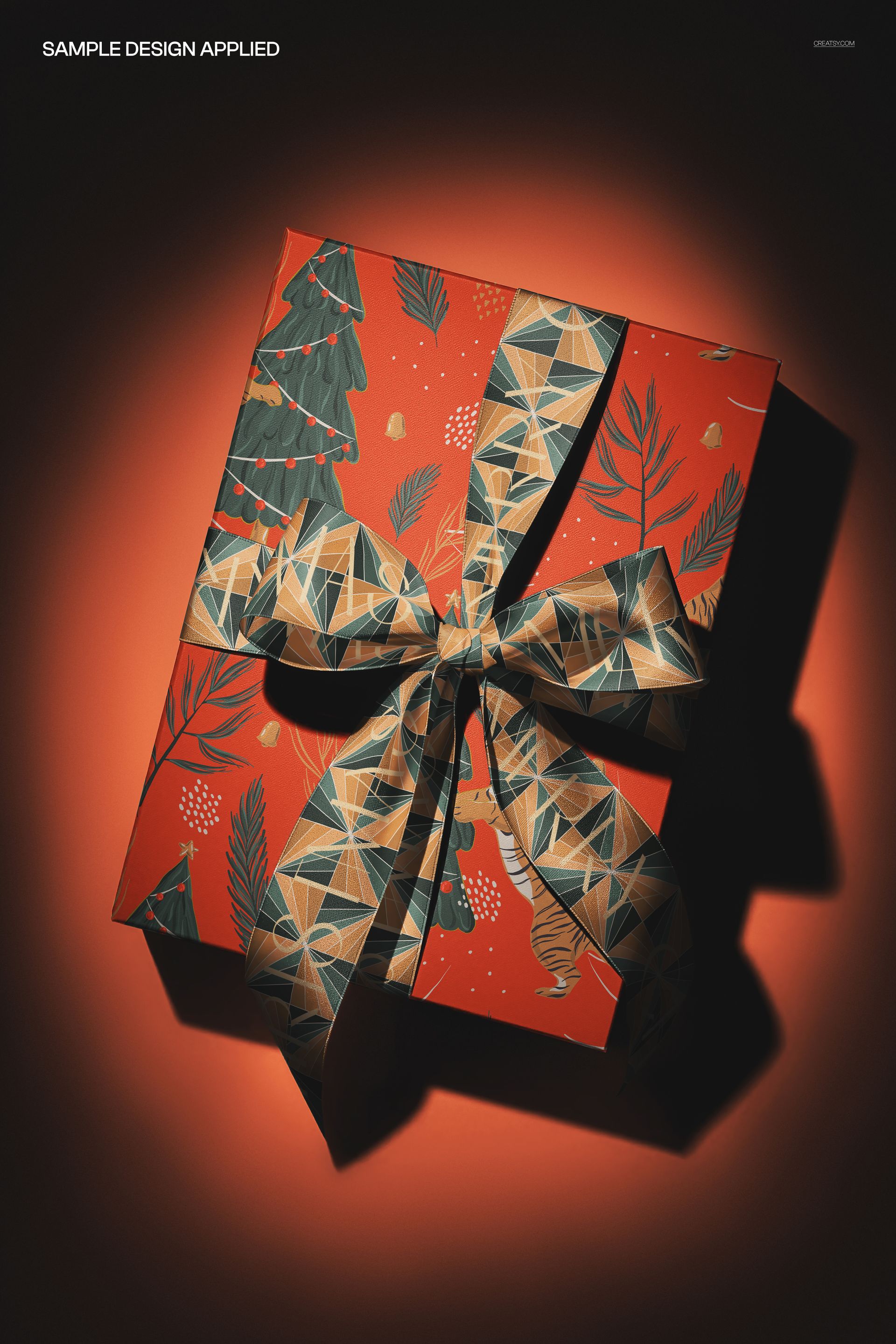 Wrapped gift box mockup featuring a geometric-patterned ribbon and holiday-themed red paper, viewed from above.