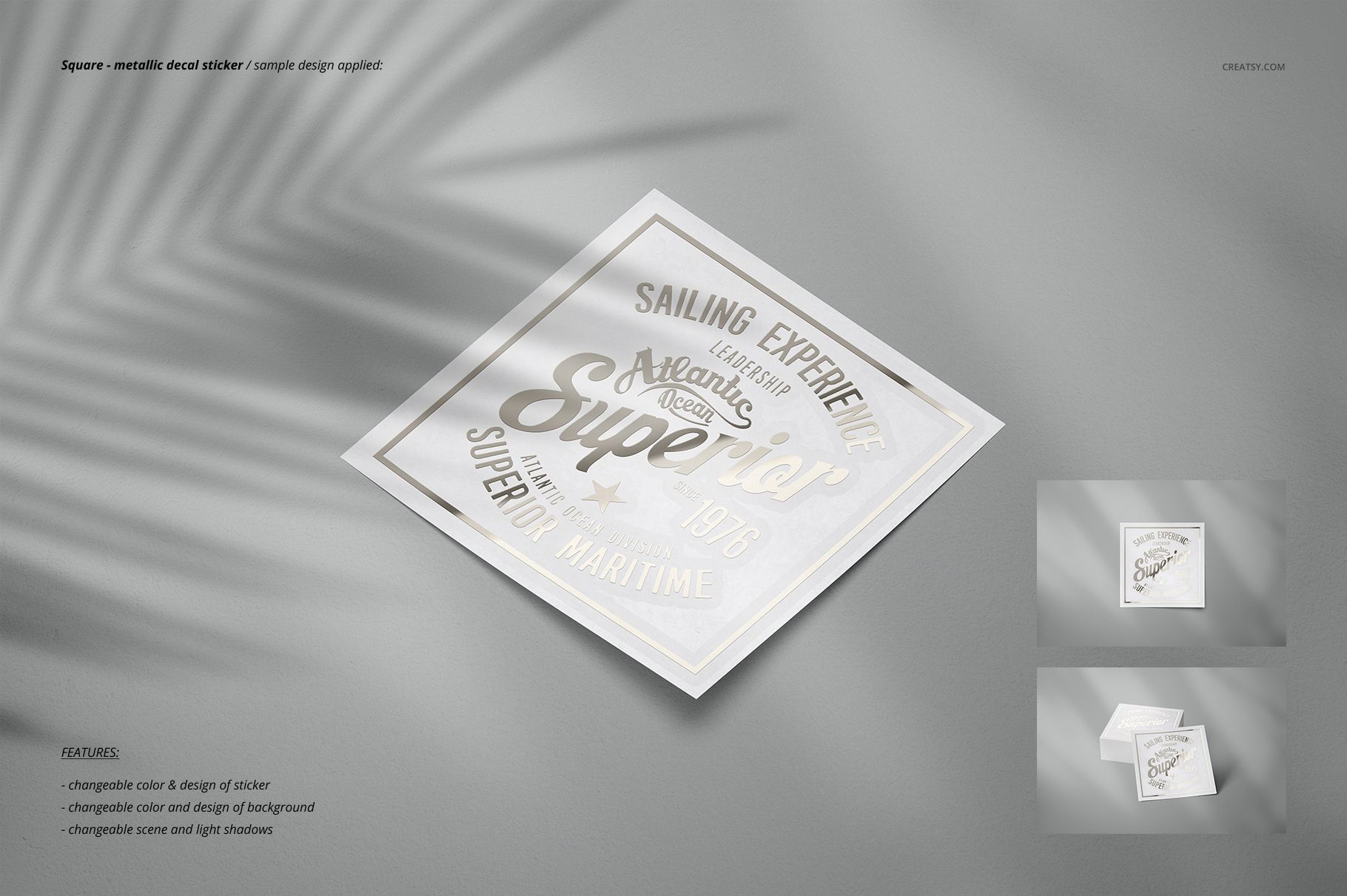 Square-shaped sticker mockup featuring a gold and white metallic print, displayed on a smooth gray background.