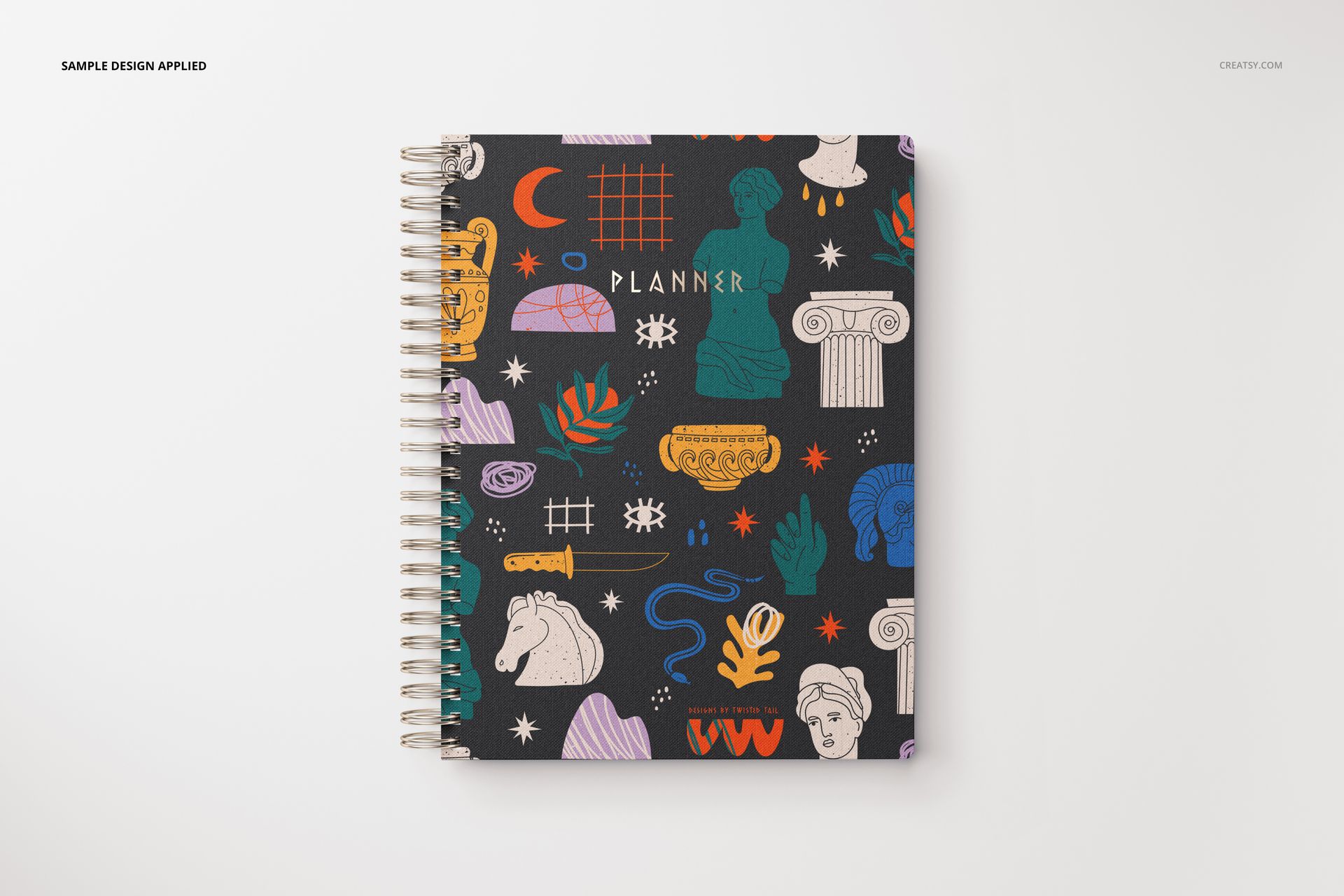 Stationery mockup featuring a spiral notebook with vibrant illustrations and classical elements on a black background.