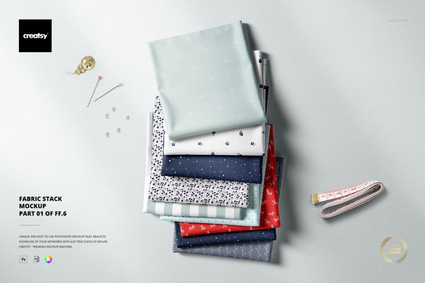 Fabric stack mockup featuring multiple folded textiles in blue, red, and white, with pins and a measuring tape.