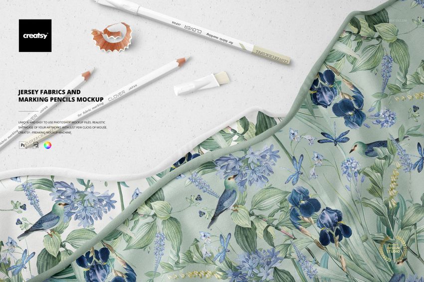 PSD mockup showing jersey fabric with a nature-inspired design, marking pencils, and a pencil shaving on a light background.
