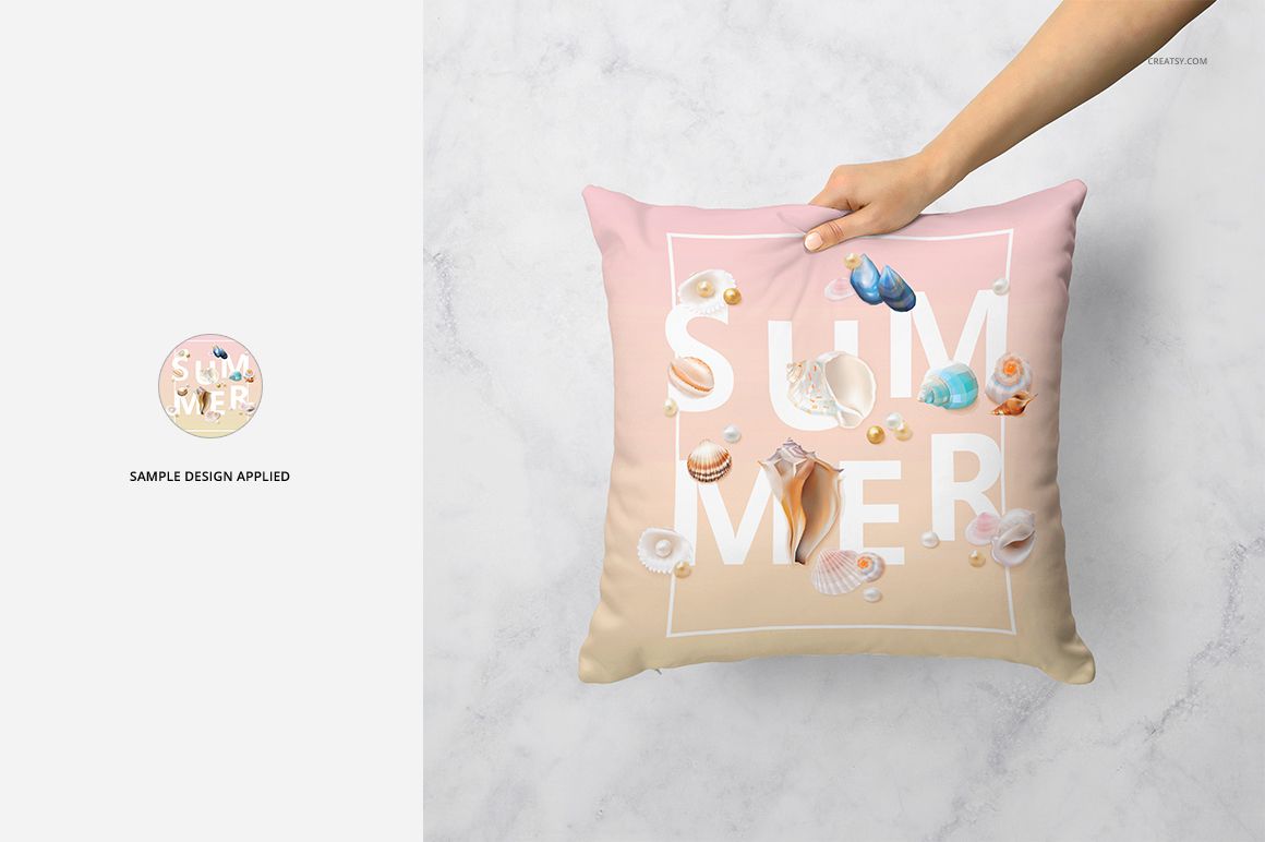 Hand holding a mockup of a square pillow with soft pastel background, seashell illustrations, and bold white letters.