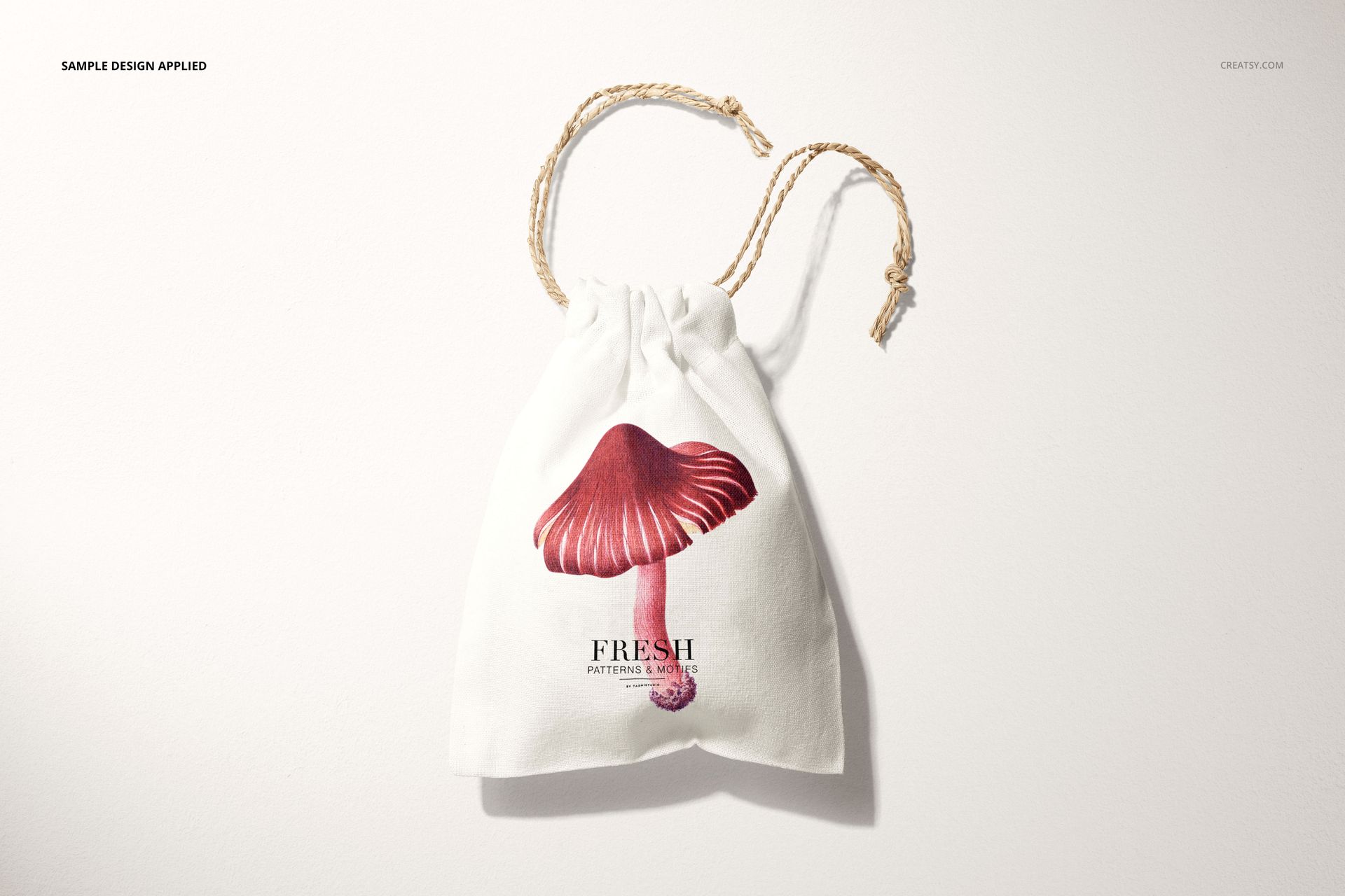 Linen drawstring bag mockup featuring a realistic mushroom illustration and twisted beige drawstrings, top view.