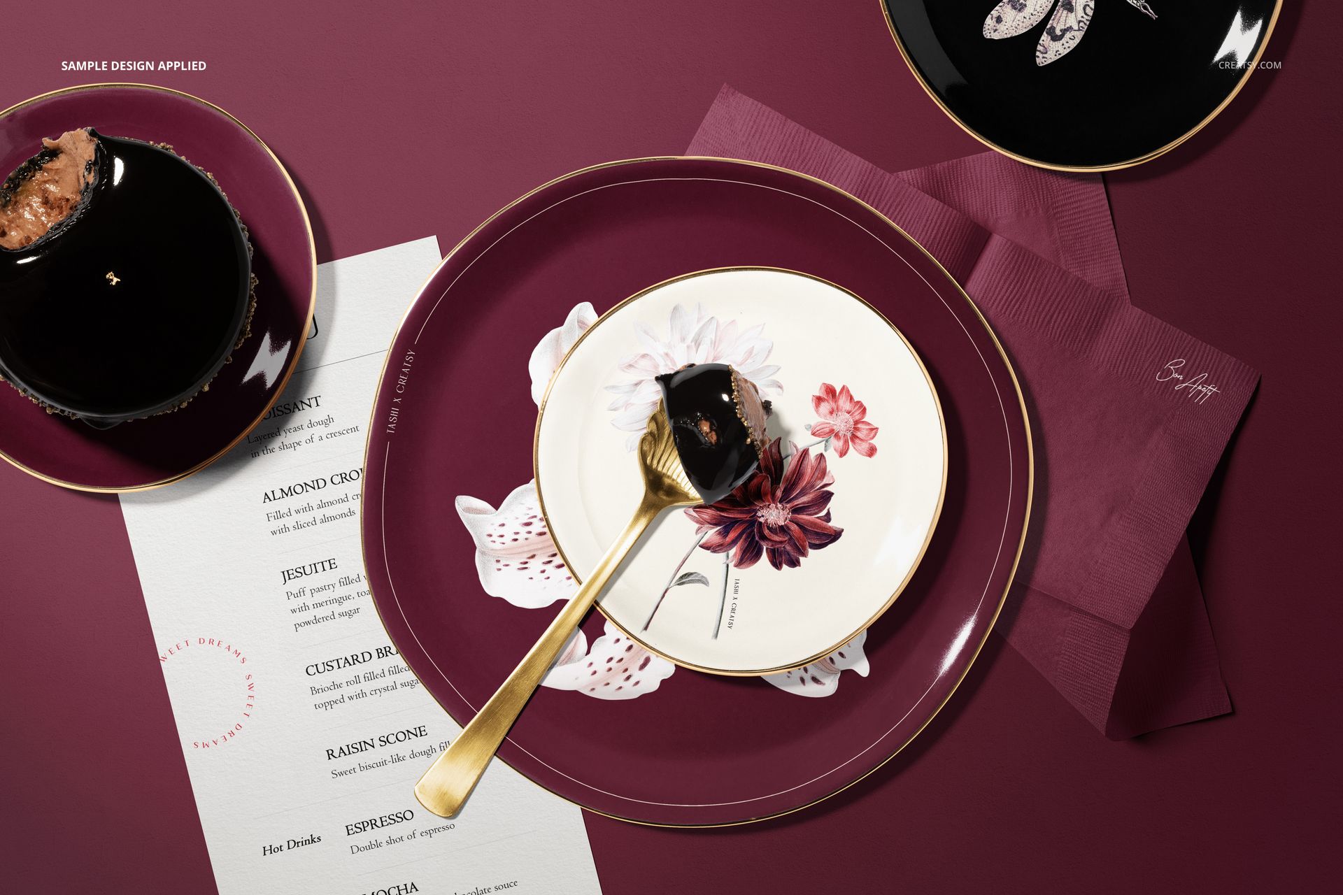 Top view of a plate mockup set with floral designs, featuring burgundy and white plates on a matching table surface.