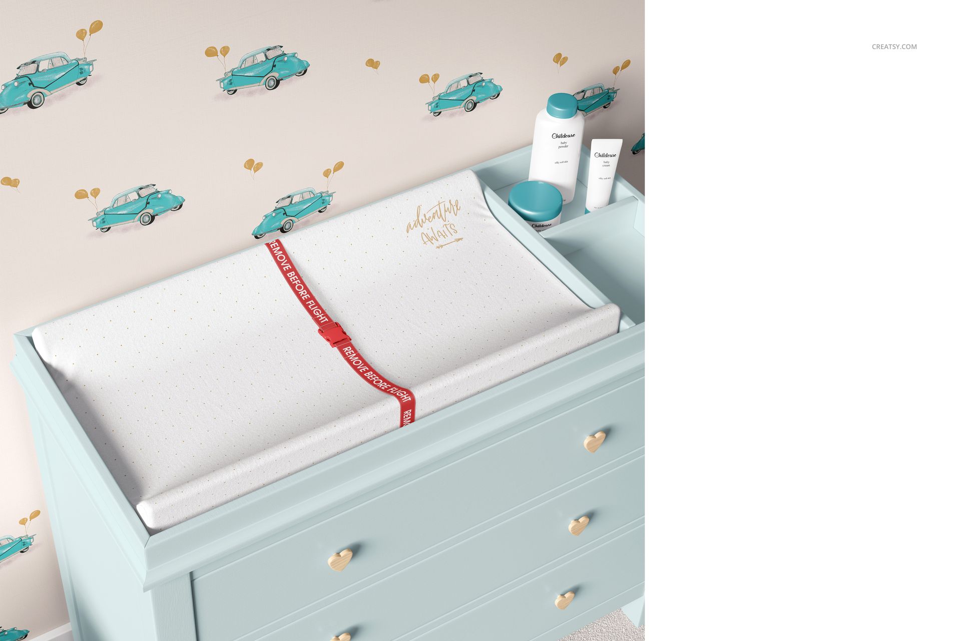 PSD mockup showing a baby room changing pad with white dotted fabric and red safety strap on a pastel dresser.