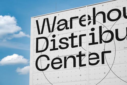 PSD mockup showing the exterior of a distribution center with geometric patterns and prominent black signage on a white surface.