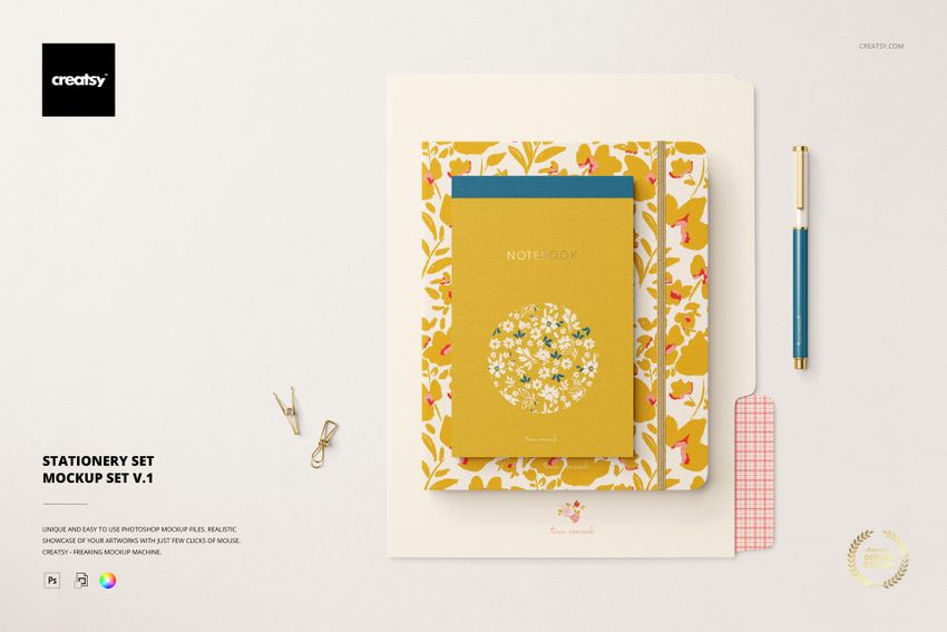 Front view of a stationery PSD mockup set with a yellow notebook, floral folder, pen, and assorted paper accessories.