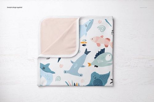 Folded cotton baby blanket mockup featuring colorful fish and sea creatures, top view on white background.