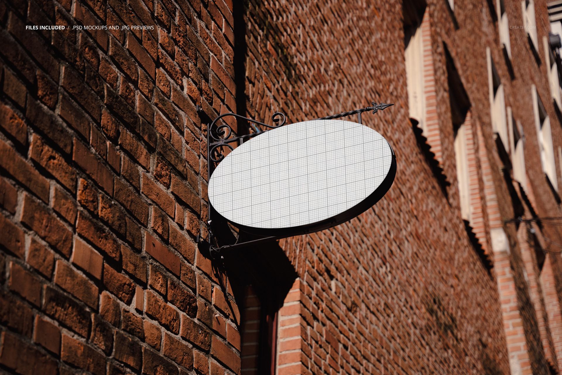 Oval signboard mockup mounted on a red brick building wall, shown from a side angle with grid overlay visible.