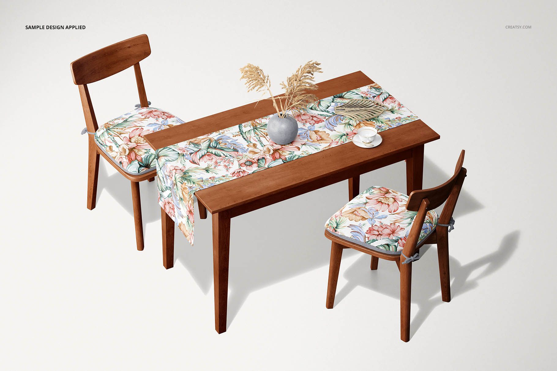 Table runner mockup featuring a floral patterned fabric on a wooden dining table with matching chair cushions, top view.