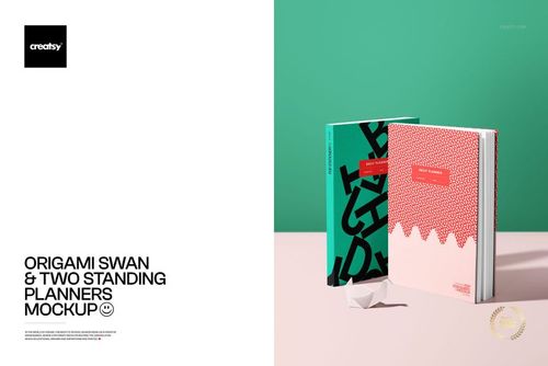 PSD mockup featuring two vertical planners with distinct patterns, accompanied by a paper origami swan on a light table.