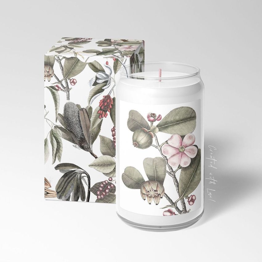 Can glass candle mockup featuring a white candle in a clear glass with a botanical floral label, next to a matching patterned box.