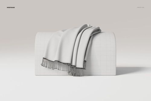 Draped throw blanket in light gray with fringed edges displayed on a curved rectangular block, front view.