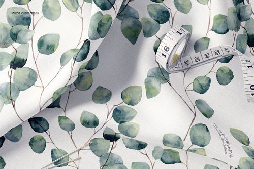 Cotton fabric mockup with leafy green watercolor design, shown in a detailed close-up with sewing tools included.