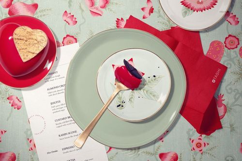Top view of a Valentine's cake plate mockup with floral pattern, gold fork, and heart-shaped cookie on a table.