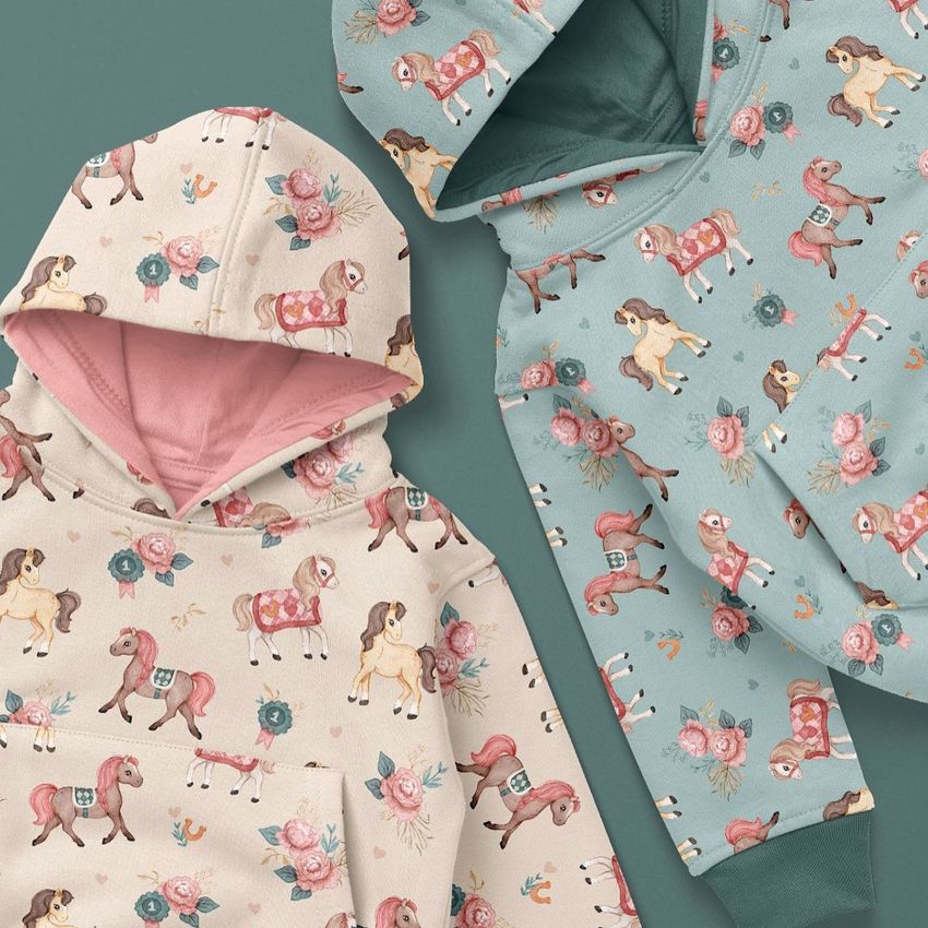 Kids pull on hoodie mockup featuring two hoodies, one beige and one light blue, both with playful horse and floral patterns.