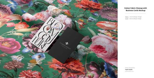 Green cotton fabric mockup with colorful flowers, shown with two business cards arranged on the surface, top-down perspective.