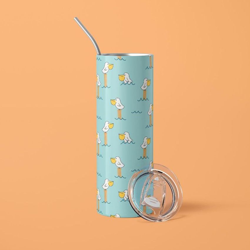 Skinny tumbler mockup with a blue background and illustrated pelicans holding cups, shown with a metal straw and clear lid.