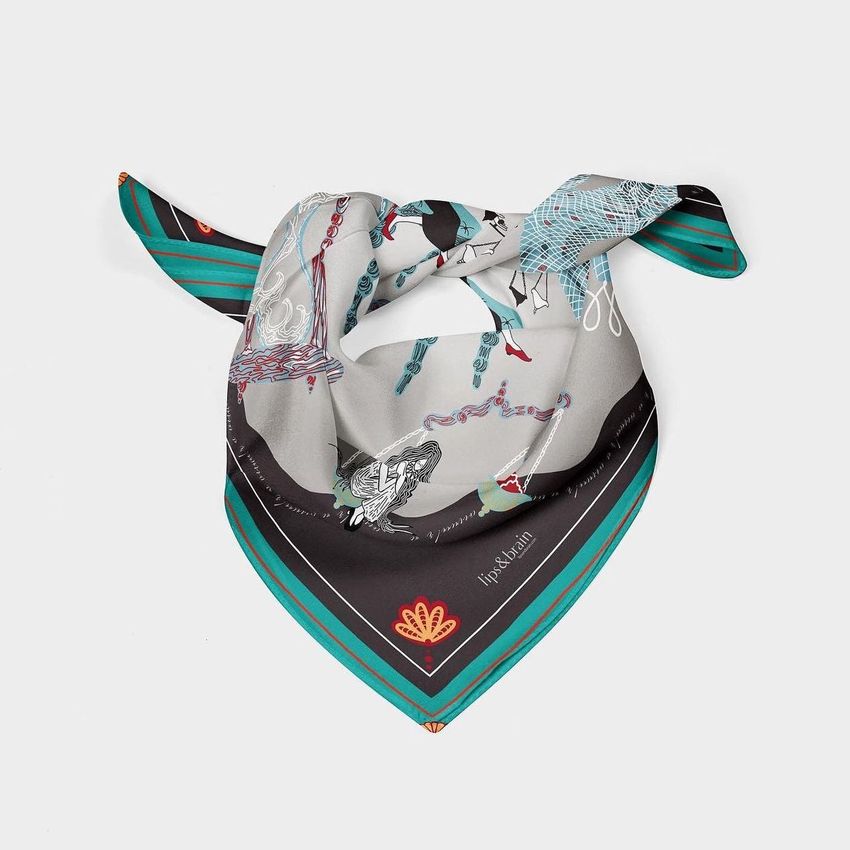 Silk scarf mockup featuring a folded scarf with green, black, and gray tones, adorned with abstract line art and patterns on a plain background.