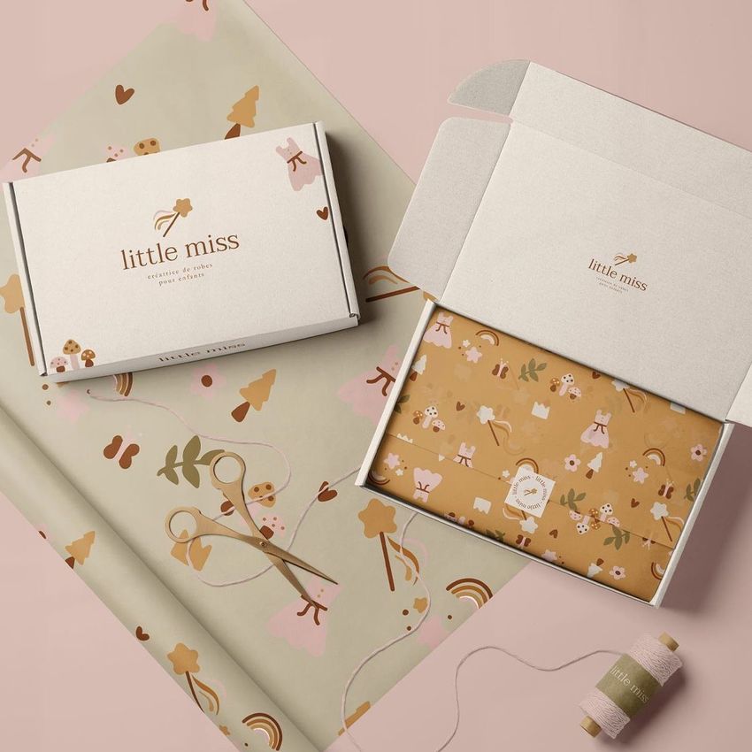 Mailing box mockup featuring one closed and one open box on a pink surface, with floral patterned tissue paper inside.