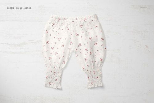 Baby summer pants mockup featuring a white fabric with tiny red flowers, shown flat on a textured white background.
