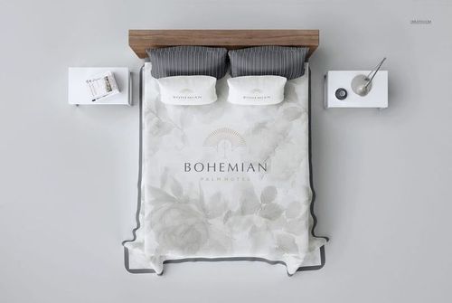 PSD mockup showing a double bed with a floral-patterned quilted coverlet, striped pillows, and minimal bedside tables.