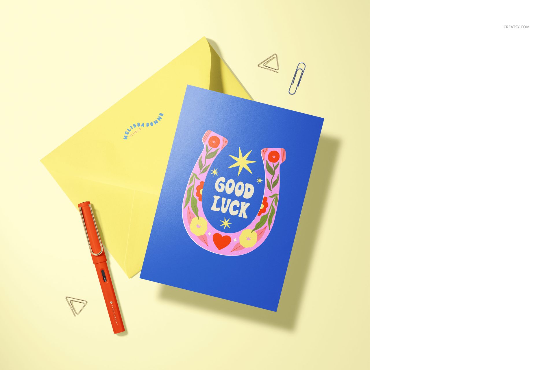 Mockup of an A5 card and envelope on a pale yellow surface, surrounded by a pen, paper clip, and geometric doodles.