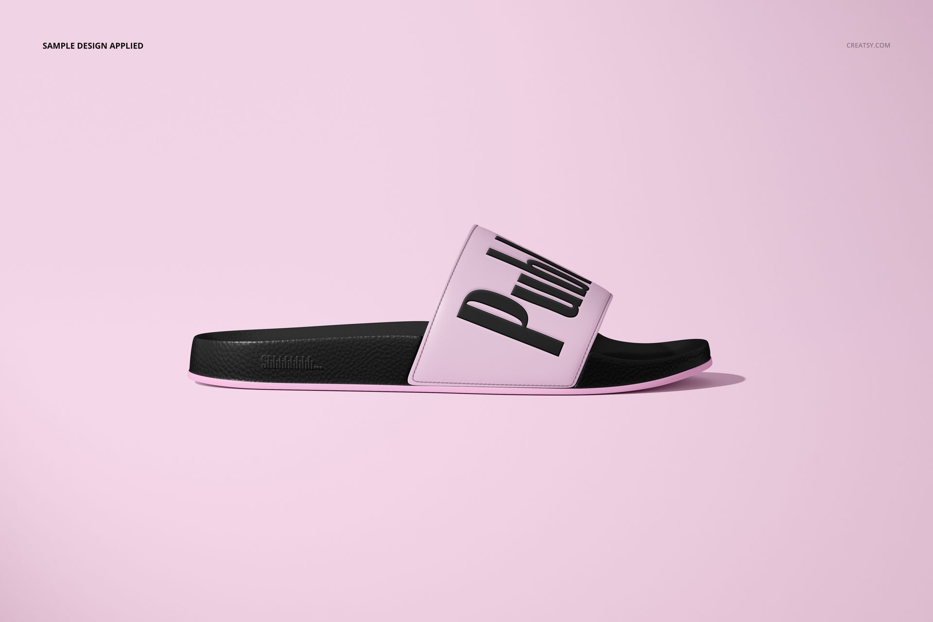 Slip-on slide sandal mockup shown in side view, featuring a black sole and pale pink strap with bold text design.
